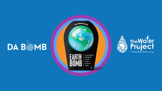 blue earth colored bath bomb in black packing, with white water project and da bomb logos on blue background
