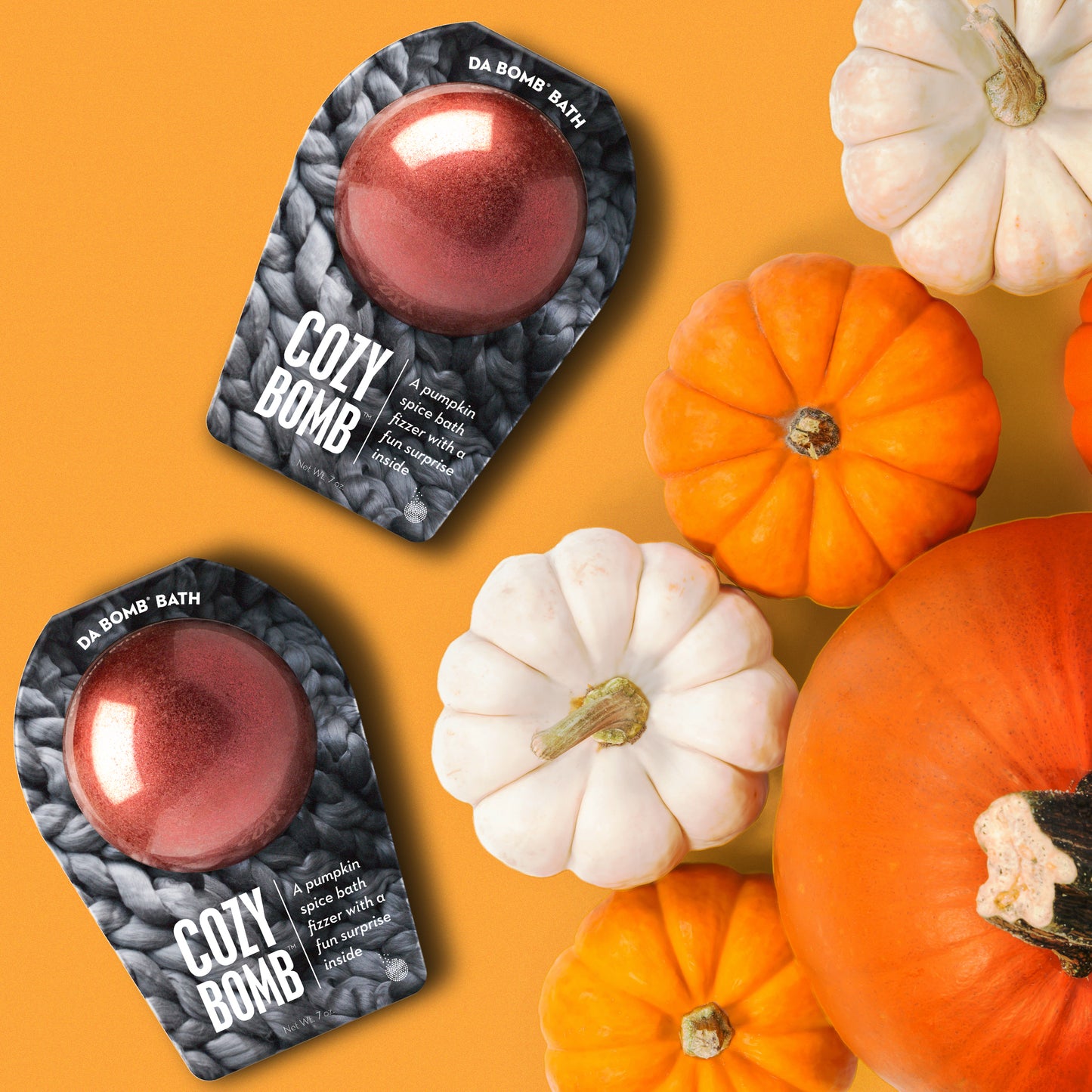 2 red bath bombs on orange background next to white and orange pumpkins