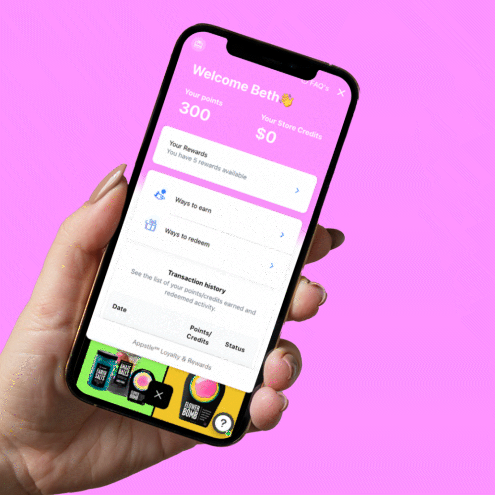 animated gif of hand holding phone with da bomb loyalty rewards on screen on pink background