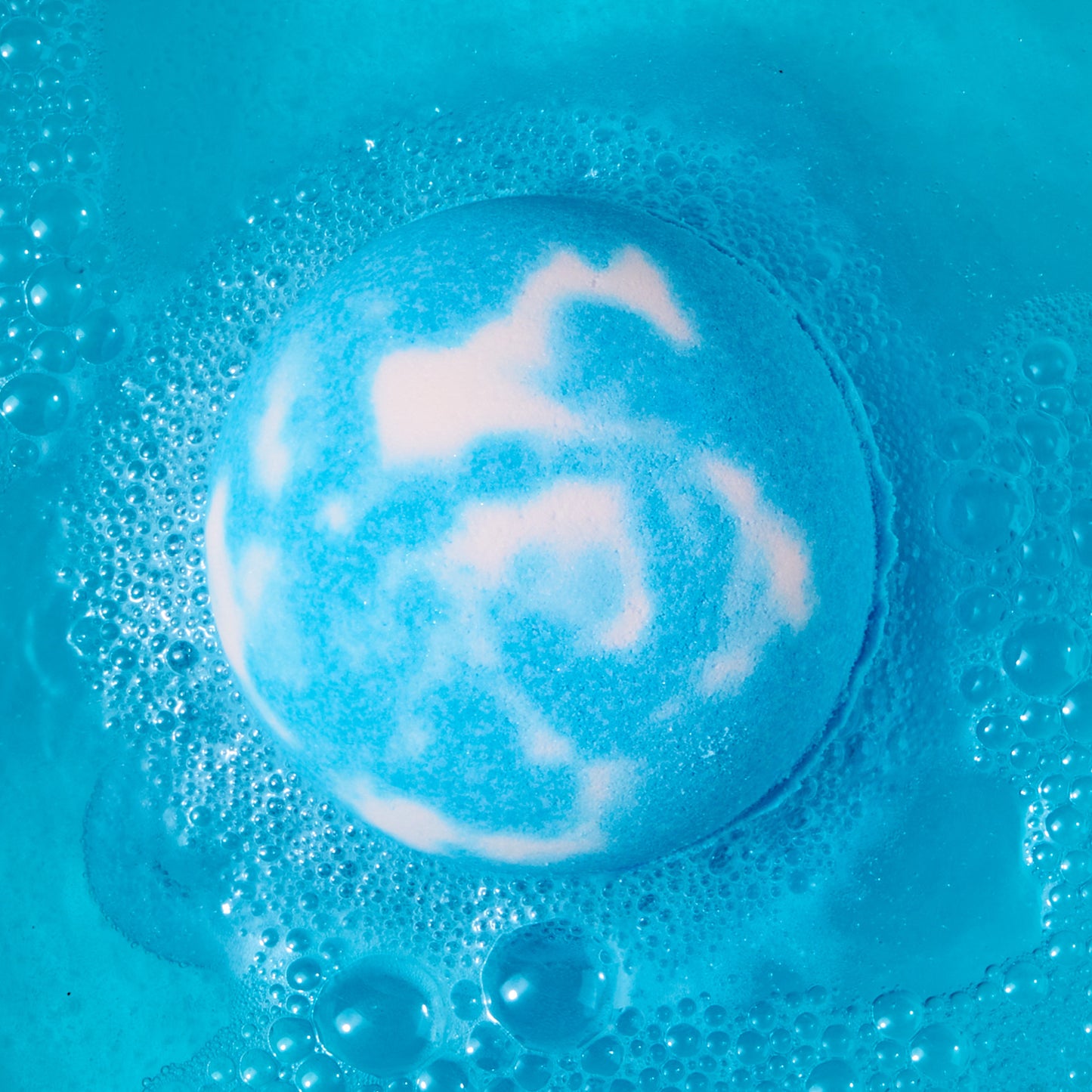 blue and white bath bomb fizzing in water