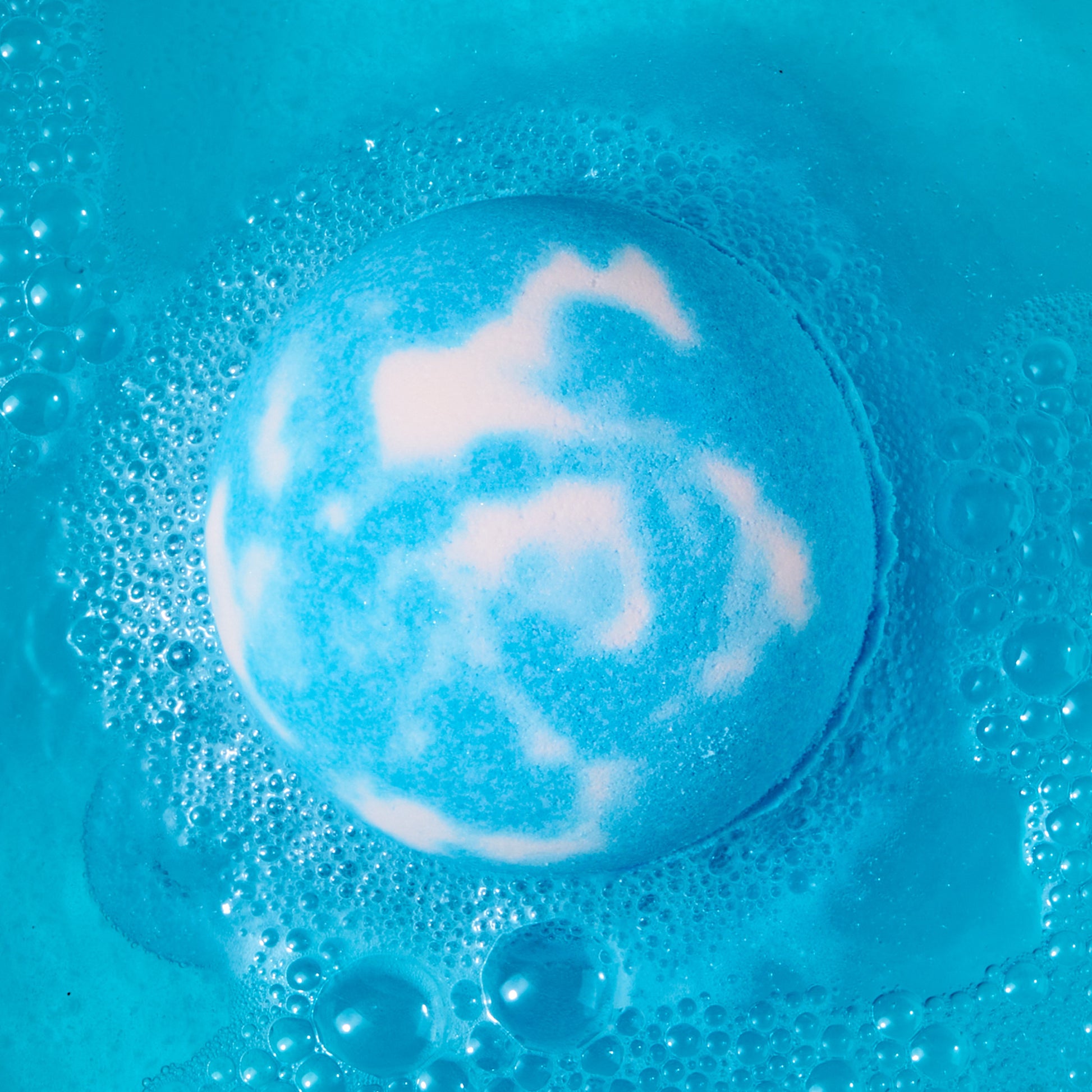 blue and white bath bomb fizzing in water