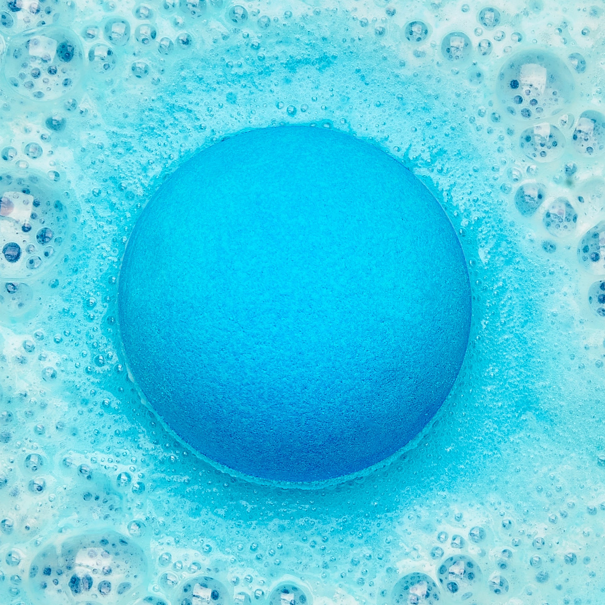 a blue fizzing bath bomb in blue bubbly water