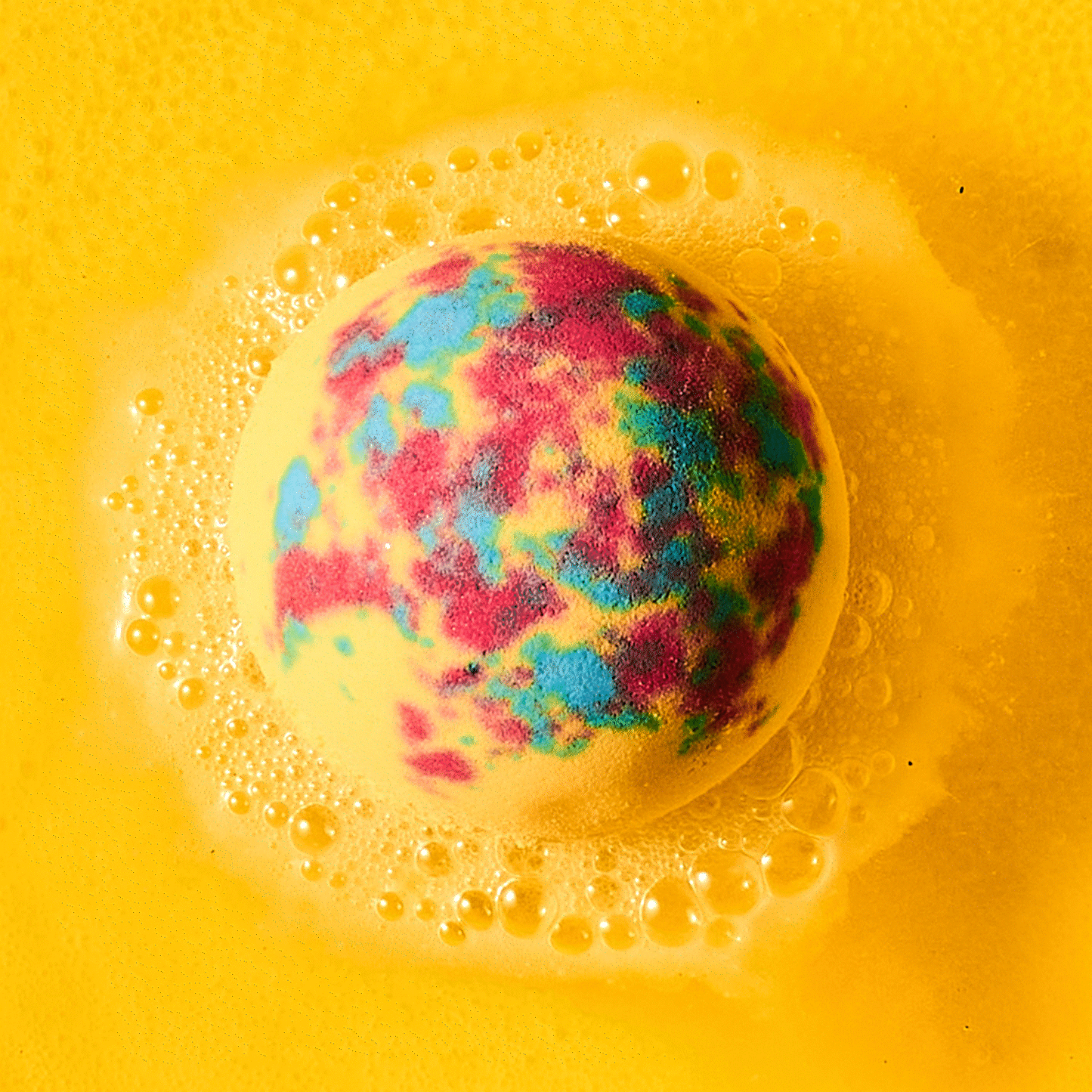 yellow bath bomb fizzing in water