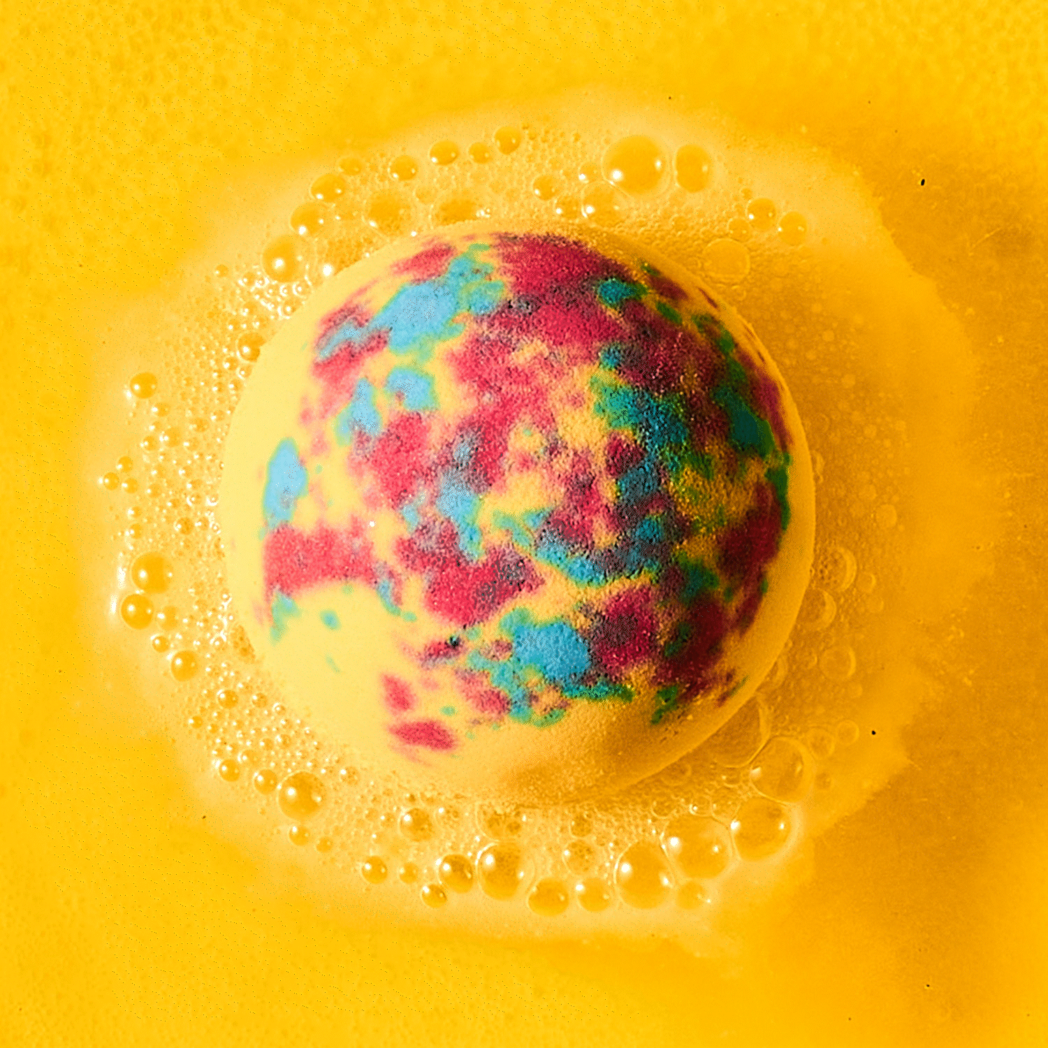 yellow bath bomb fizzing in water