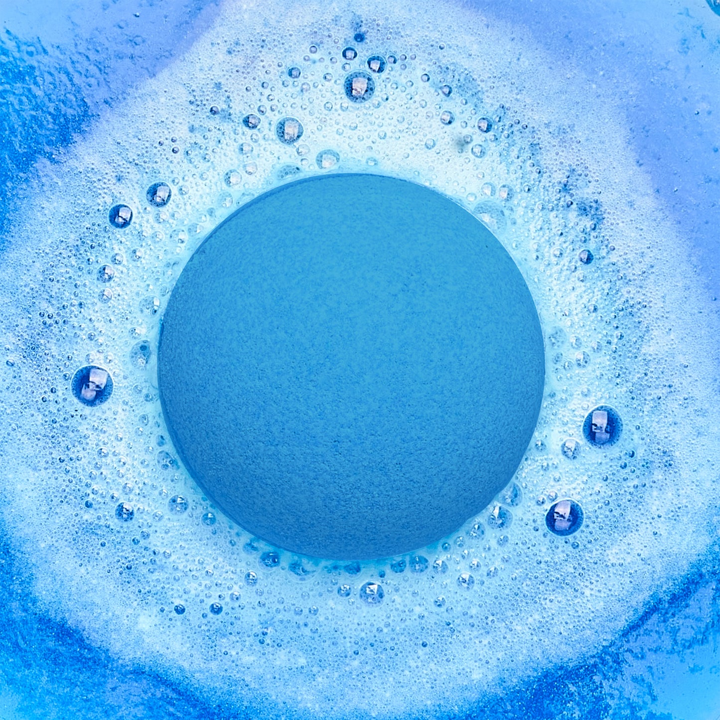 a blue fizzing bath bomb in blue water
