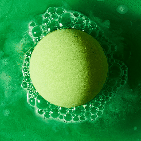 fizzing green glow bath bomb dissolving in water