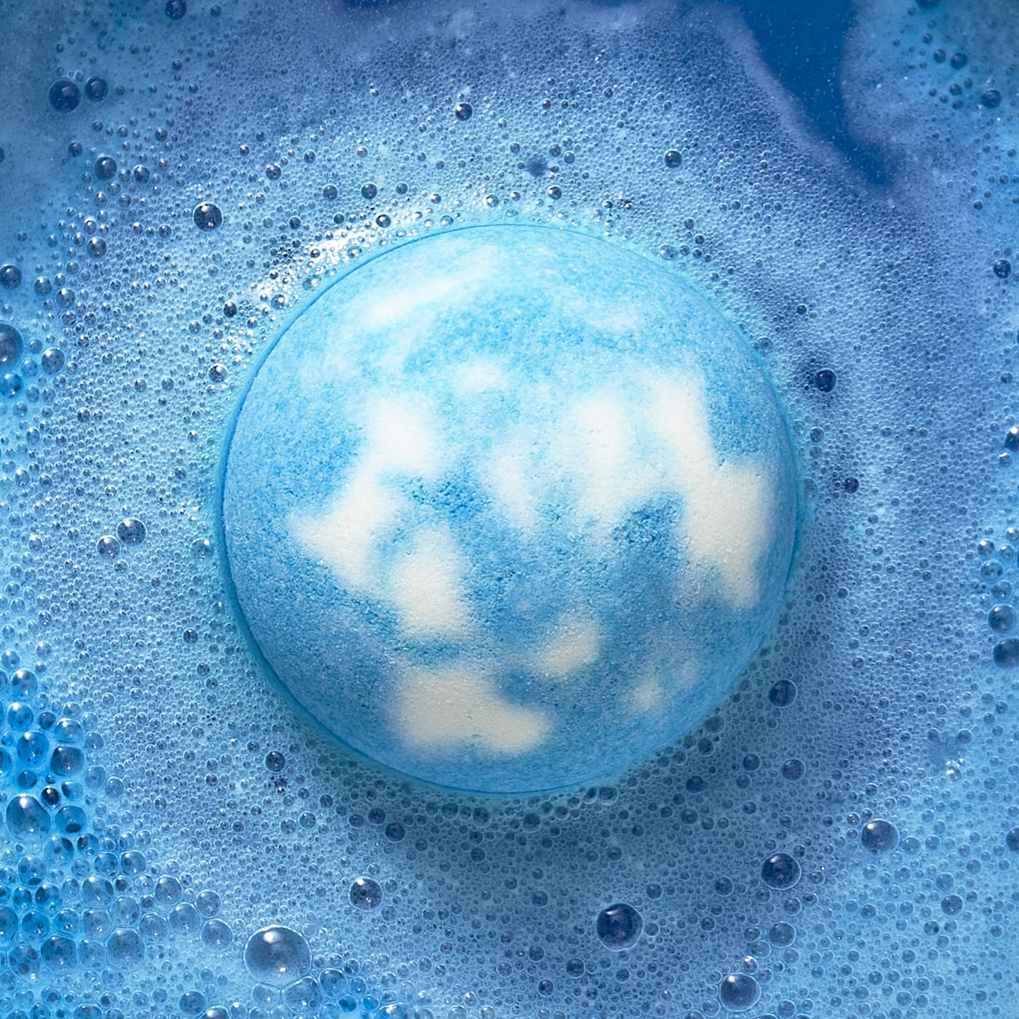 Blue and white bath bomb fizzing in water