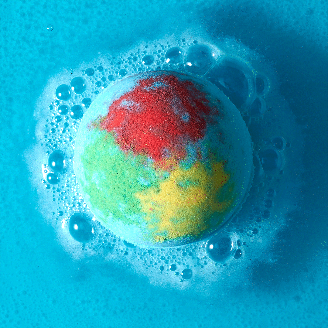 blue bath bomb with yellow, red and green powder fizzing in blue water
