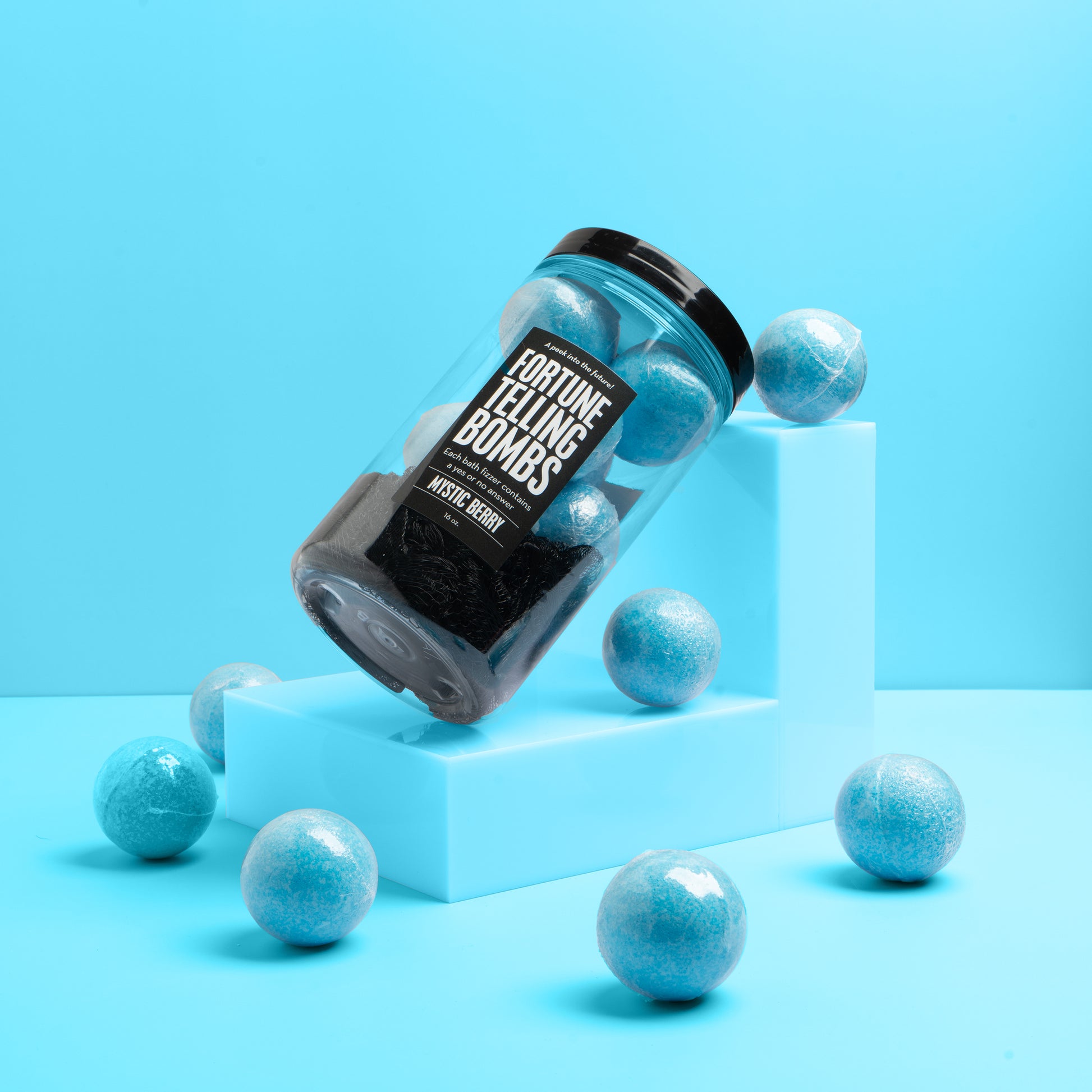 a jar of blue bath bombs leaning on a blue block