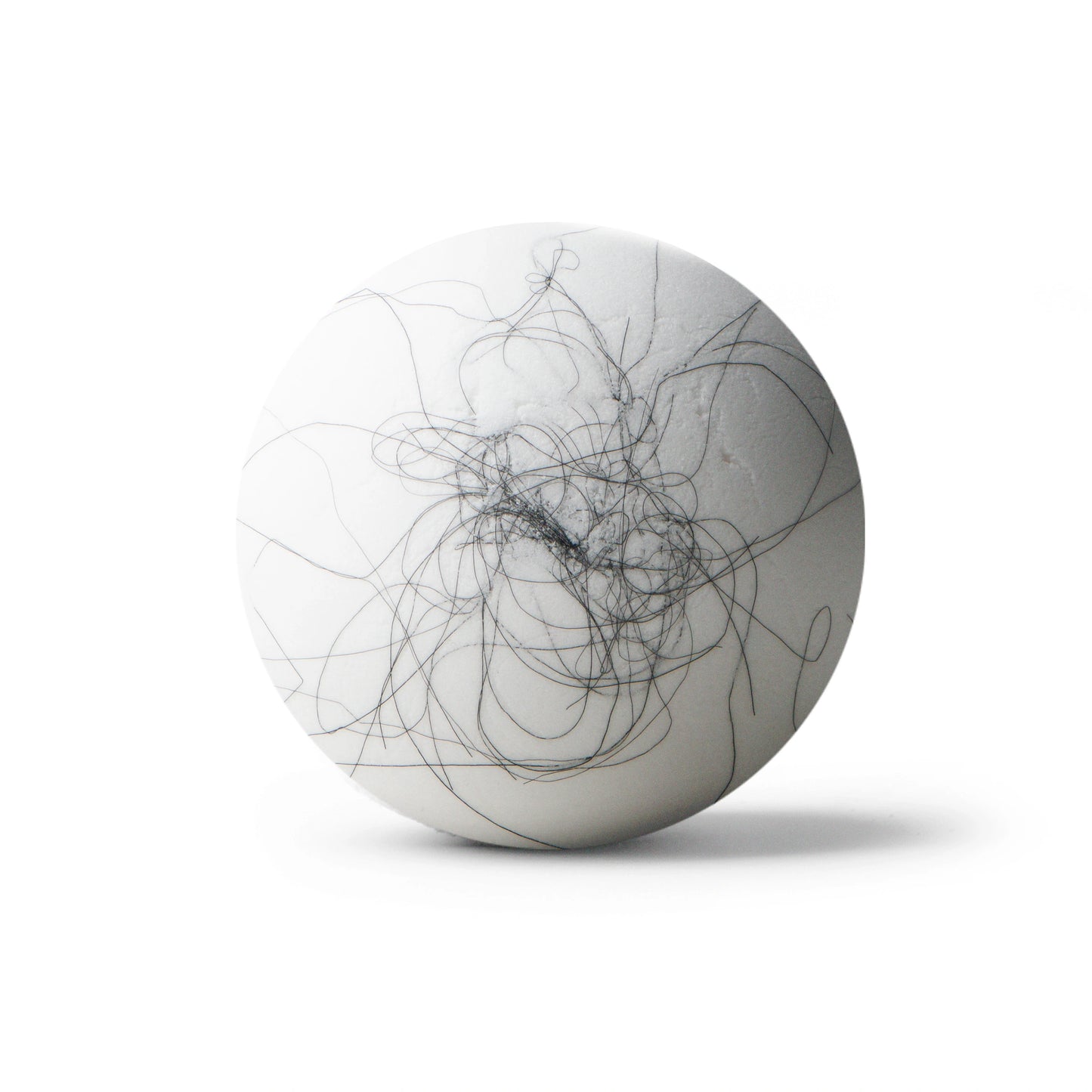 White bath bomb with black hair on white background