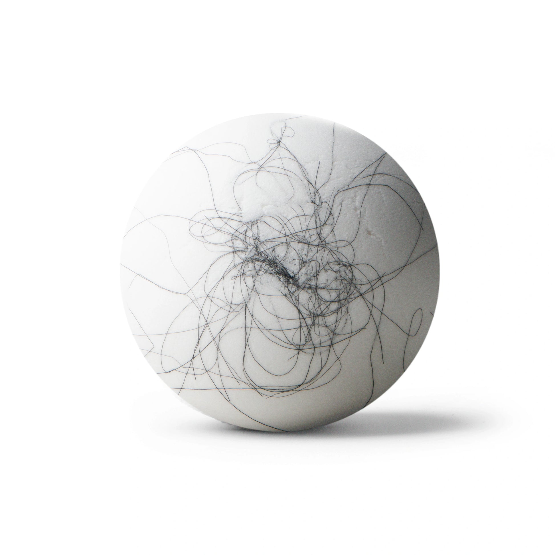 White bath bomb with black hair on white background