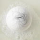 Animated GIF of a white bath bomb fizzing in water with black strands of hair 