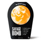 a white and orange bath bomb in black packaging