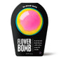 blue bath bomb with pink and yellow circles in black packaging