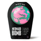 green and pink bath bomb in black packaging 