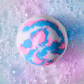 white, pink and blue unicorn bath bomb fizzing in water