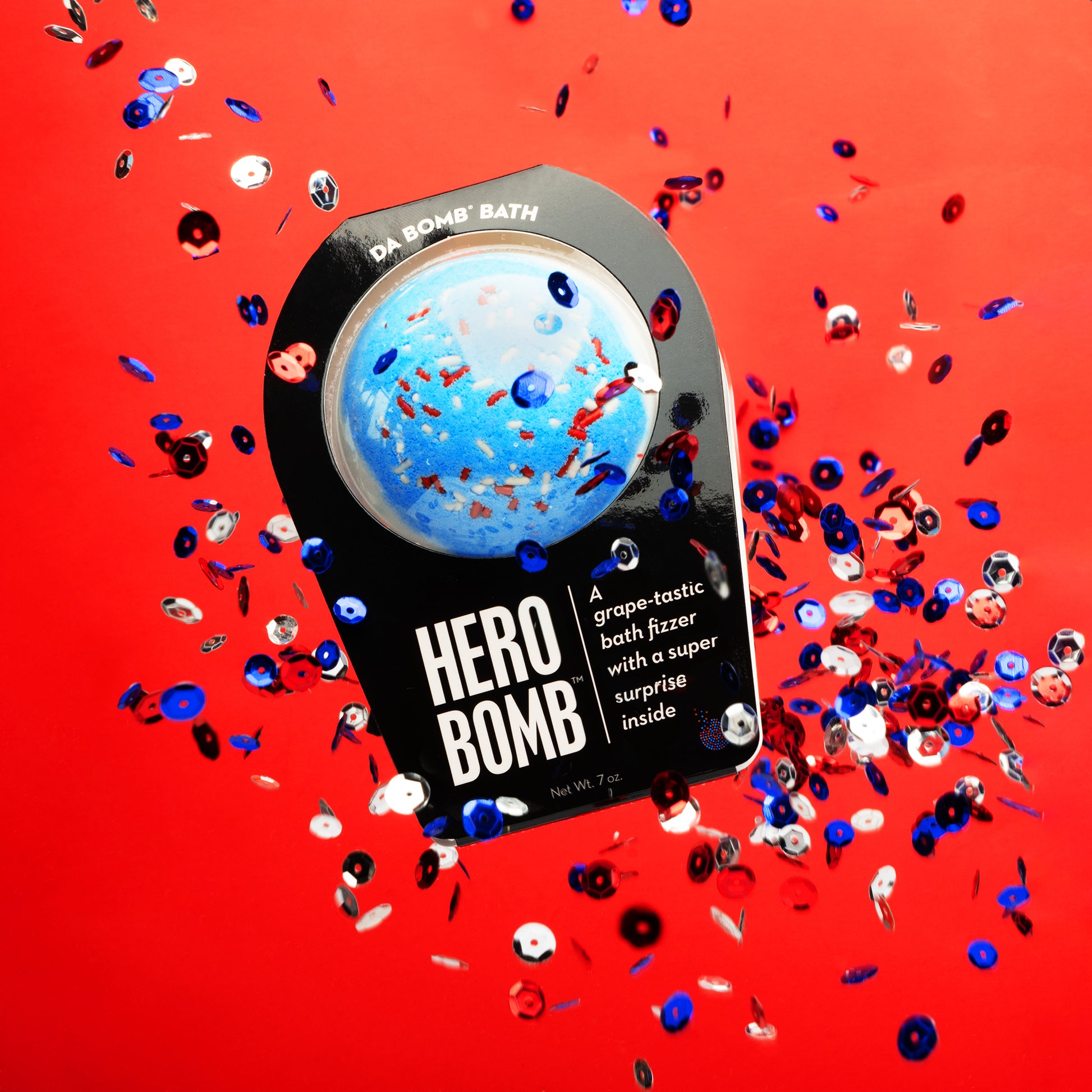 a blue bath bomb on a red background floating in the air with confetti behind it