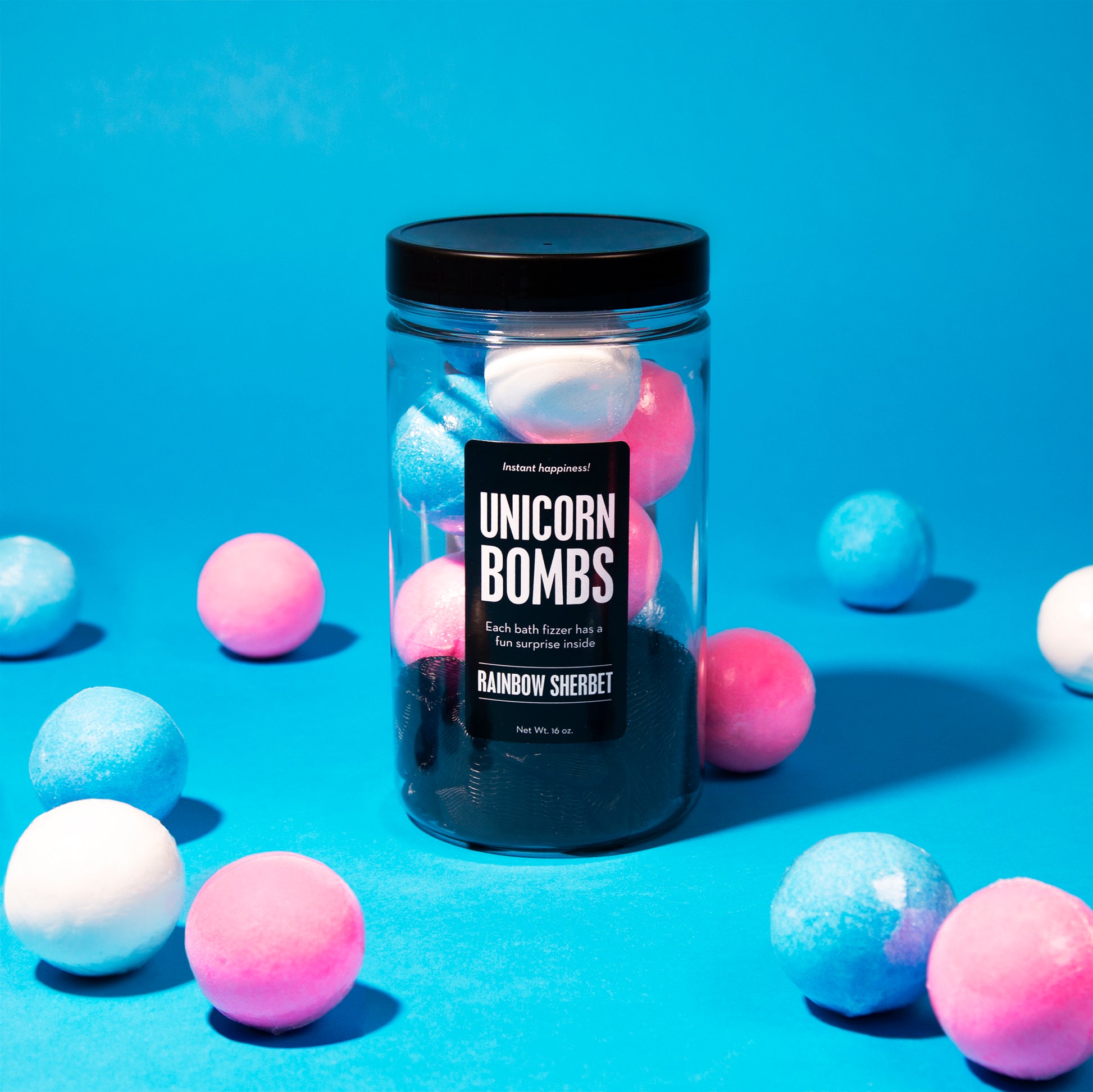 bath bomb jar in middle of blue, pink and white bath bombs on blue background